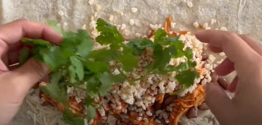 Adding cilantro to burrito